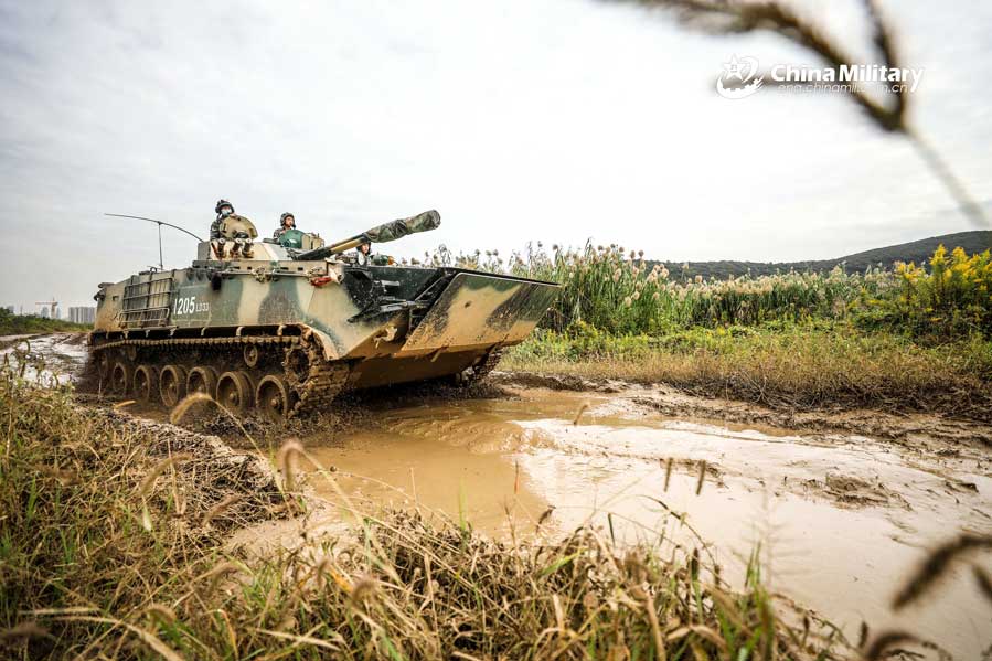 Infantry fighting vehicles drive through mire
